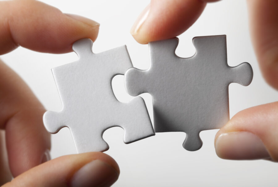 Puzzle pieces coming together representing connection and collaboration within Transitional Care Services